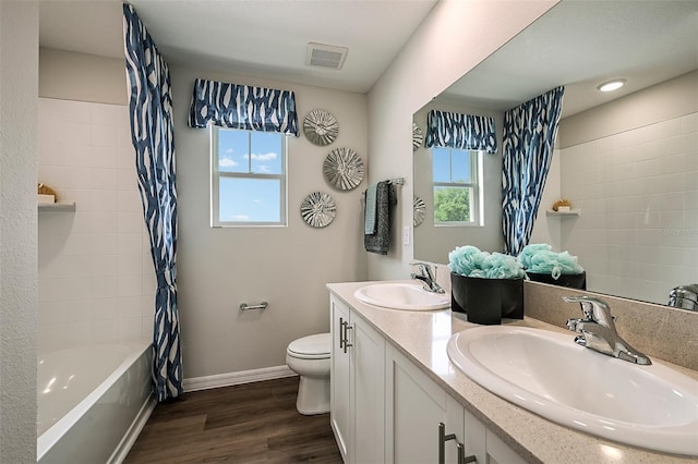 full bathroom featuring a wealth of natural light, vanity, wood-type flooring, and toilet