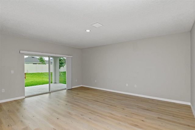 spare room featuring a textured ceiling and light wood-type flooring