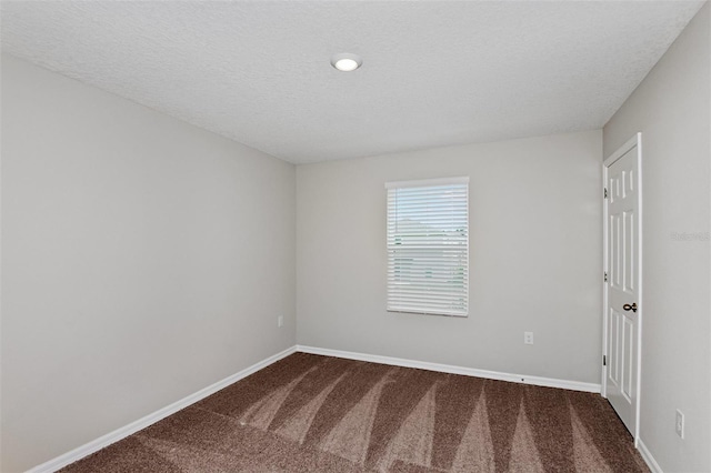 carpeted spare room with a textured ceiling