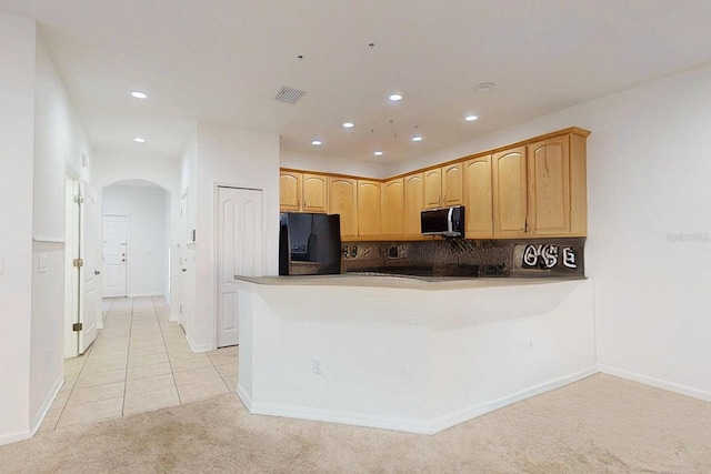 kitchen featuring kitchen peninsula, light brown cabinetry, backsplash, black fridge with ice dispenser, and light colored carpet