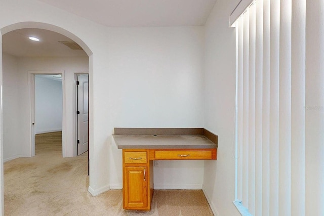 unfurnished office featuring light carpet and built in desk