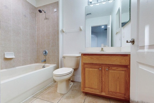 full bathroom featuring tile patterned floors, vanity, tiled shower / bath, and toilet