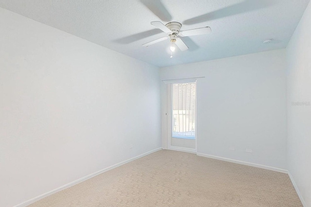 empty room with ceiling fan, carpet, and a textured ceiling