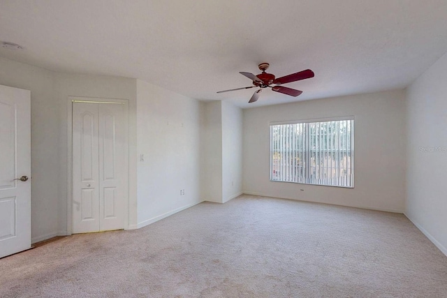 carpeted spare room with ceiling fan