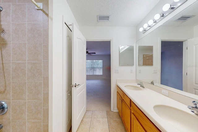 bathroom with tile patterned floors, ceiling fan, vanity, and a textured ceiling