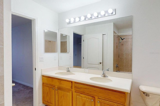 bathroom featuring a tile shower, vanity, and toilet