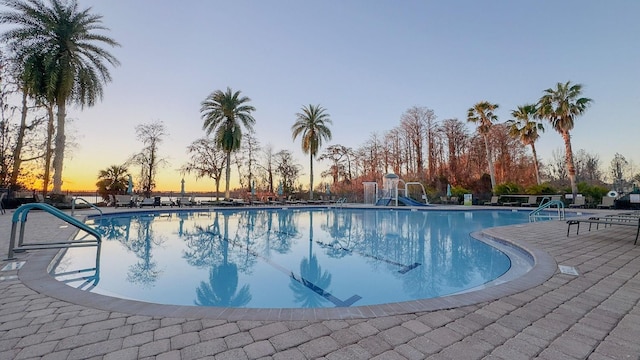 pool at dusk featuring a patio area