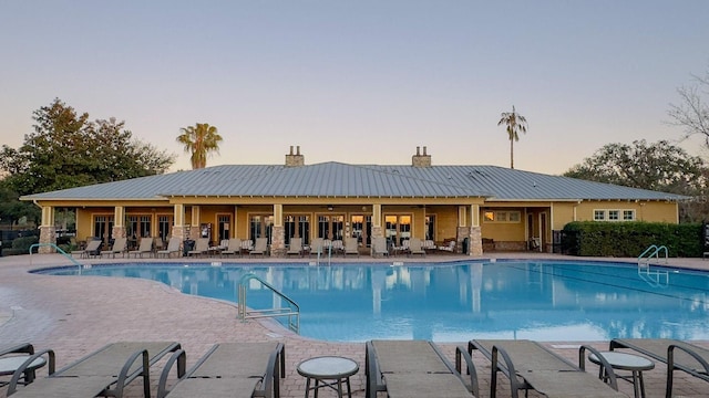 pool at dusk with a patio