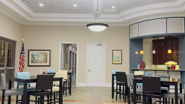 dining room featuring a raised ceiling and ornamental molding