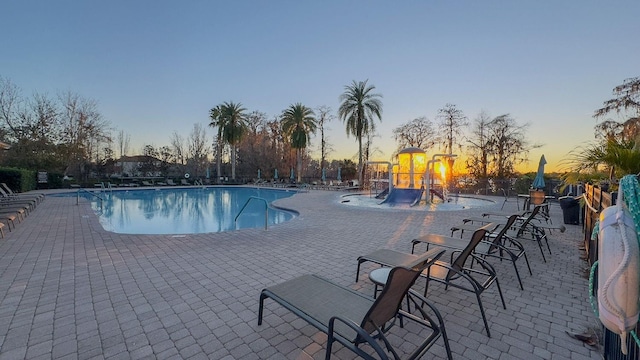 pool at dusk featuring a patio