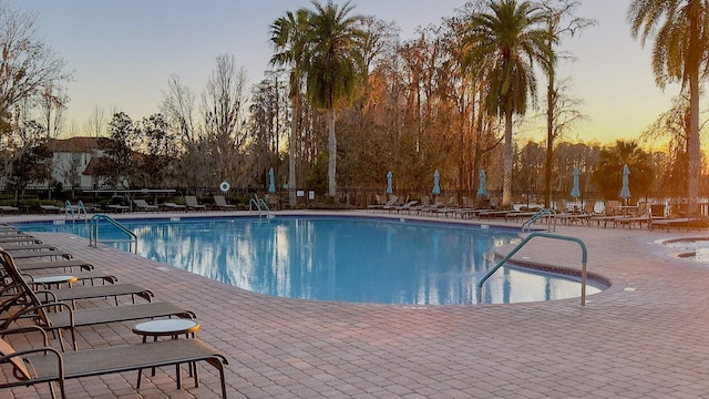 pool at dusk with a patio