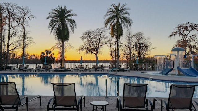 pool at dusk with a patio area