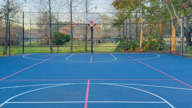 view of sport court with a lawn