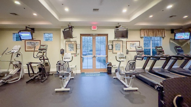 workout area with a tray ceiling and french doors