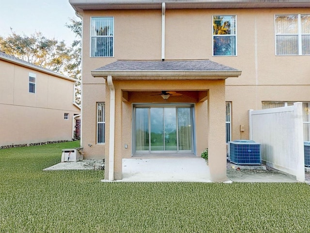 rear view of house featuring ceiling fan, cooling unit, a yard, and a patio