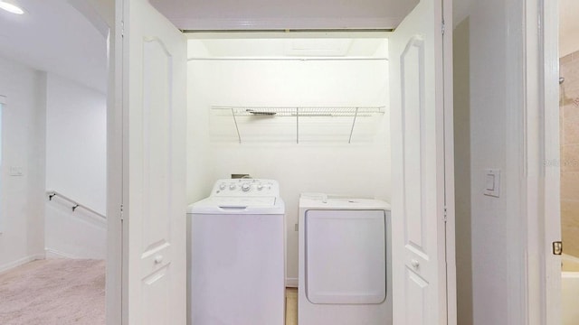 clothes washing area with washer and dryer and light carpet