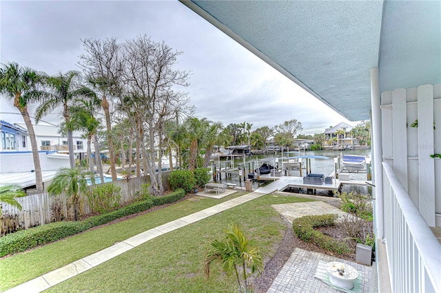 exterior space with a water view, boat lift, and a lawn