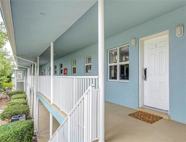 property entrance with central AC and stucco siding