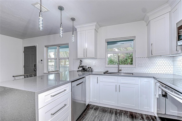 kitchen featuring stainless steel appliances, a peninsula, a sink, visible vents, and light stone countertops