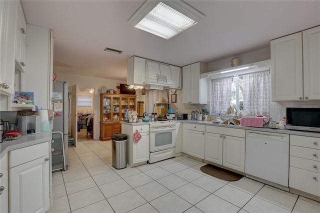 kitchen with white cabinetry, sink, stainless steel appliances, kitchen peninsula, and decorative backsplash