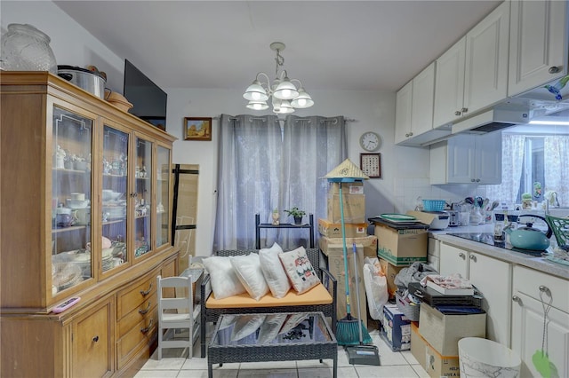 kitchen with a notable chandelier, white cabinetry, and decorative light fixtures