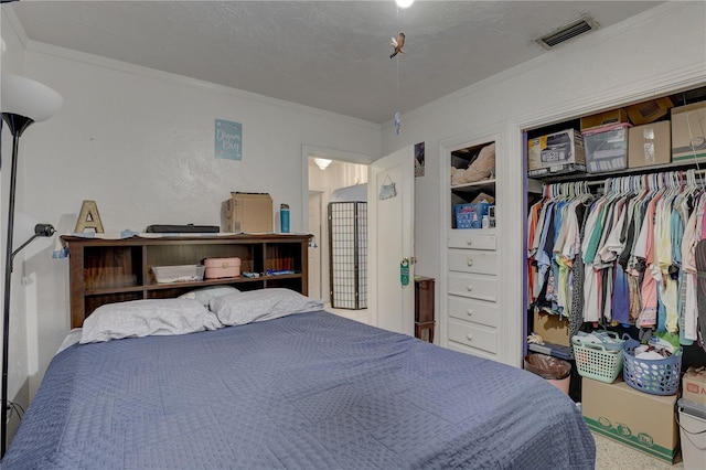 bedroom with a closet, a textured ceiling, and ornamental molding