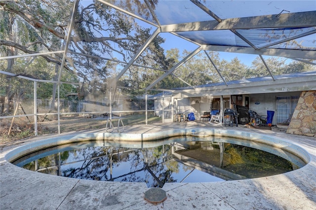 view of pool featuring glass enclosure and a patio