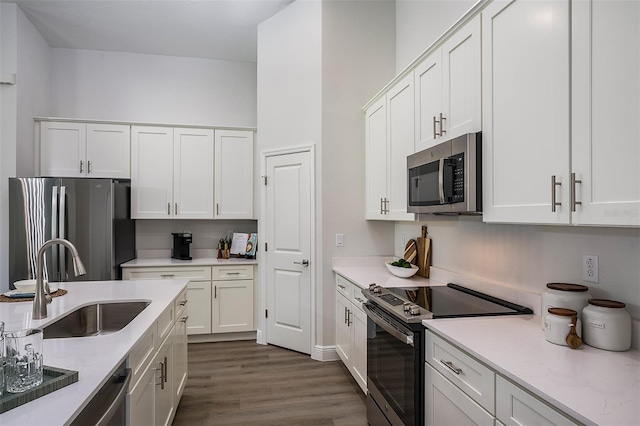 kitchen with dark hardwood / wood-style flooring, white cabinetry, sink, and appliances with stainless steel finishes