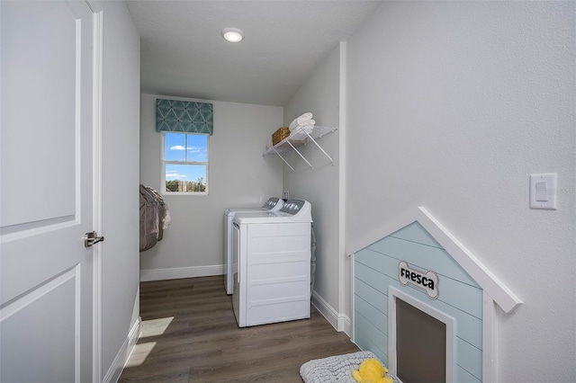 laundry room with washer and clothes dryer and dark wood-type flooring