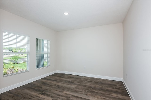 unfurnished room with dark wood-type flooring