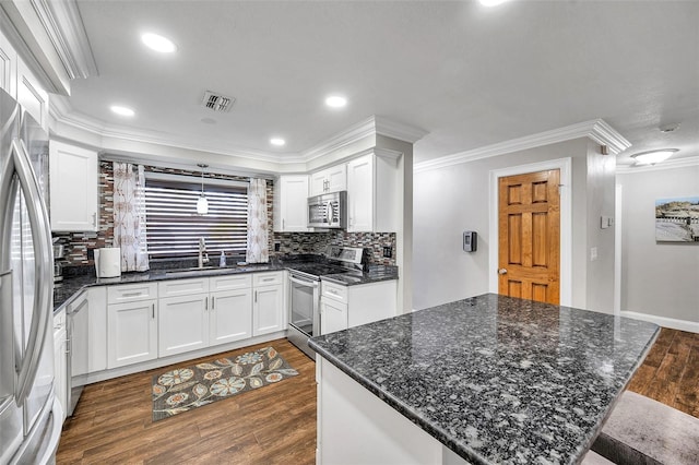 kitchen featuring decorative backsplash, white cabinetry, sink, and stainless steel appliances