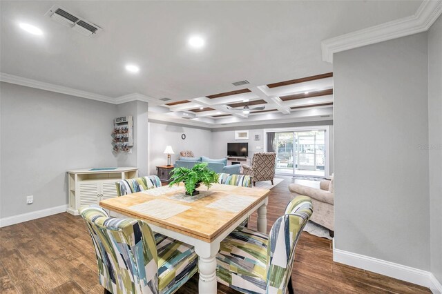 dining space featuring beam ceiling, coffered ceiling, dark hardwood / wood-style flooring, crown molding, and a fireplace