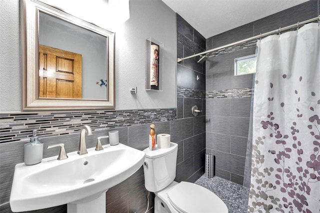 bathroom featuring backsplash, sink, a shower with shower curtain, toilet, and tile walls