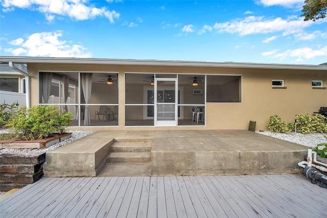 rear view of property featuring a deck, ceiling fan, and a sunroom