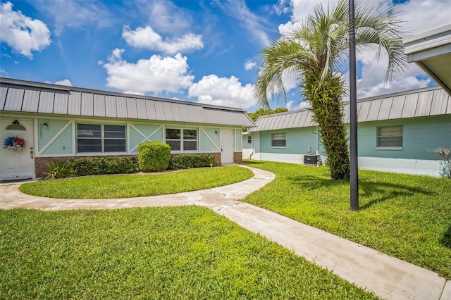 ranch-style home featuring a front yard and central AC unit