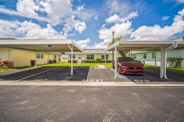 view of car parking featuring a lawn and a carport