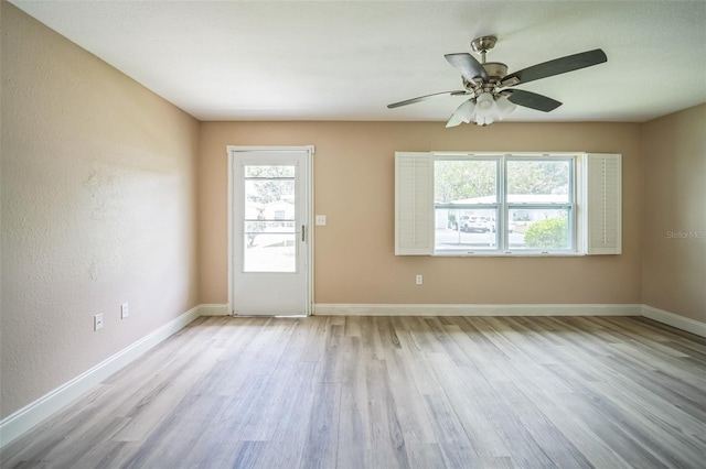 spare room with light hardwood / wood-style floors, ceiling fan, and a healthy amount of sunlight