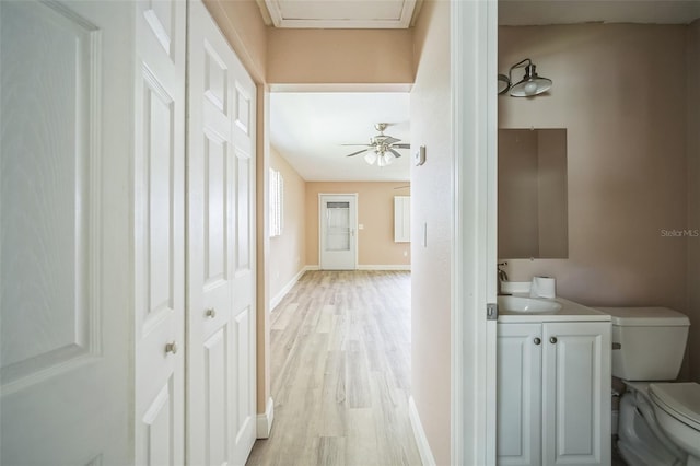 hallway with light wood-type flooring and sink