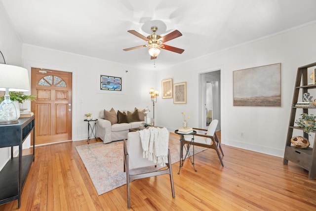 living room with ceiling fan, ornamental molding, and light wood-type flooring