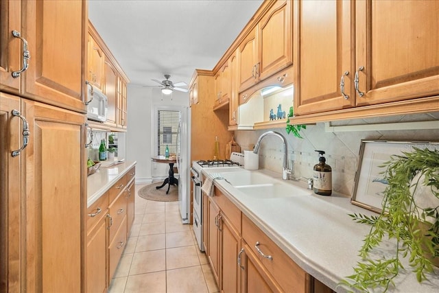 kitchen with sink, decorative backsplash, light tile patterned floors, ceiling fan, and white appliances