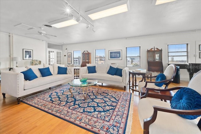 living room featuring wood-type flooring, rail lighting, and ceiling fan