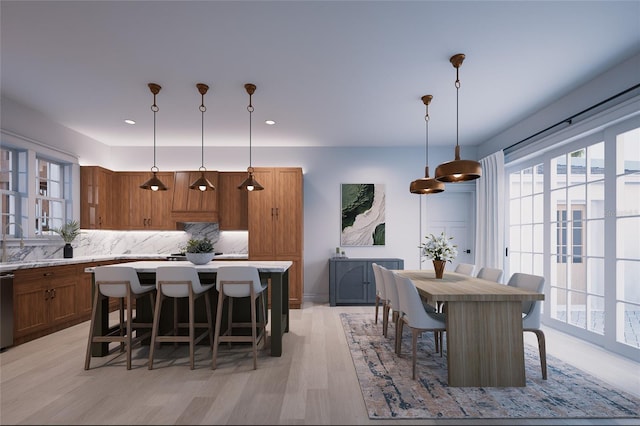 kitchen with tasteful backsplash, a kitchen bar, decorative light fixtures, and a kitchen island