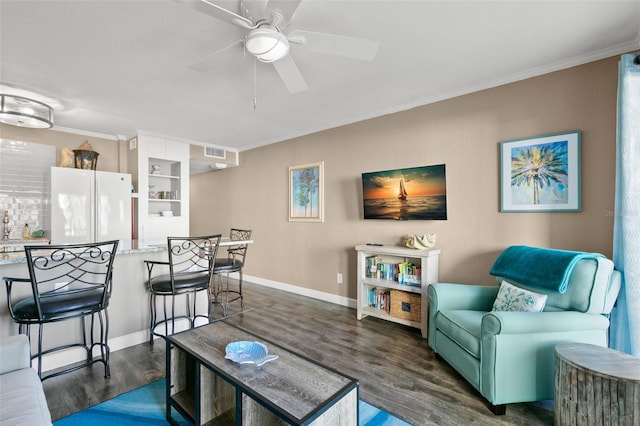 living room featuring ceiling fan, dark hardwood / wood-style flooring, and crown molding