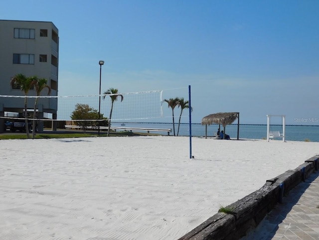 view of home's community with a water view and volleyball court