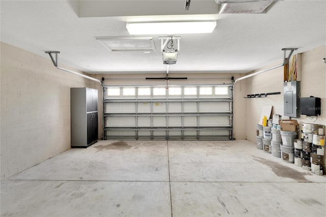 garage with a garage door opener and electric panel