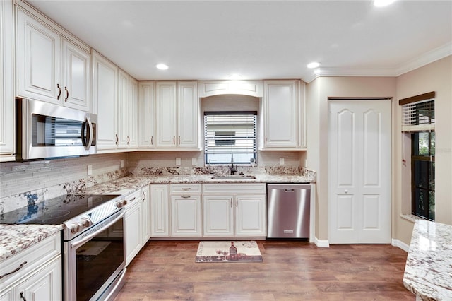 kitchen featuring dark wood-type flooring, stainless steel appliances, light stone countertops, and sink