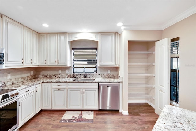 kitchen with sink, light stone countertops, dark hardwood / wood-style floors, and appliances with stainless steel finishes