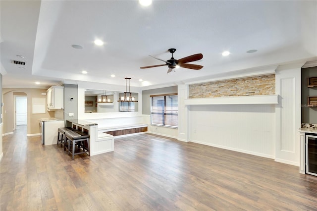 unfurnished living room featuring dark wood-type flooring and ceiling fan