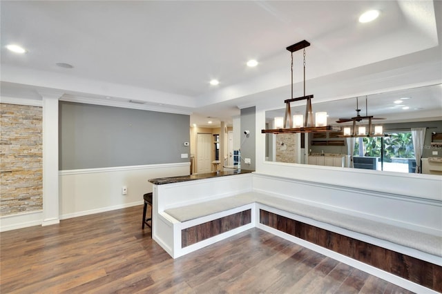 kitchen featuring dark hardwood / wood-style flooring, hanging light fixtures, and a kitchen bar