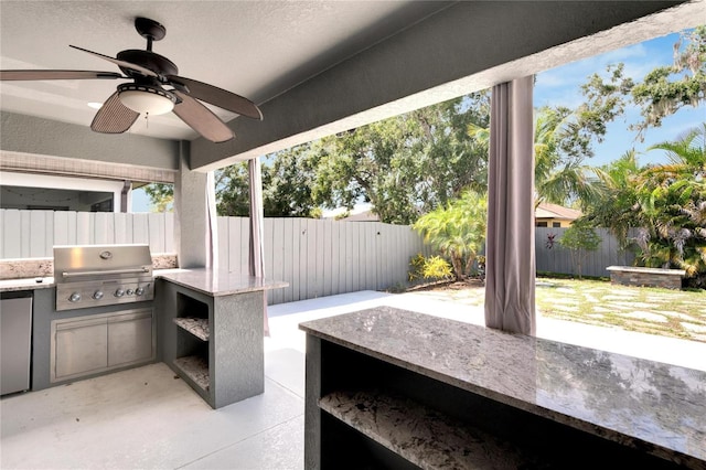 view of patio / terrace featuring grilling area, ceiling fan, and exterior kitchen